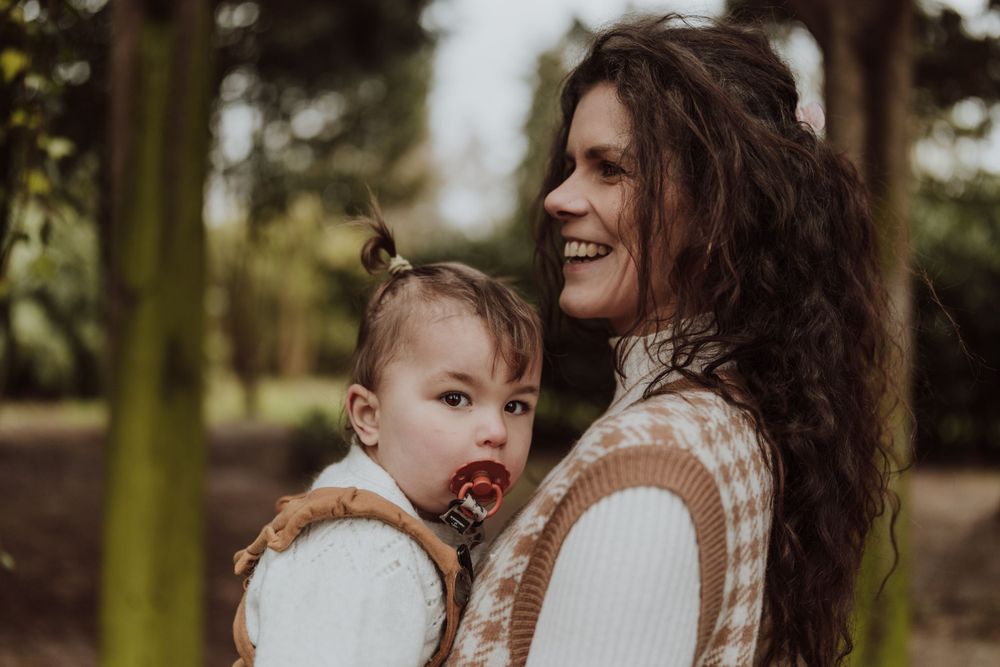 Sweet candid moment between parent and child in outdoor setting.