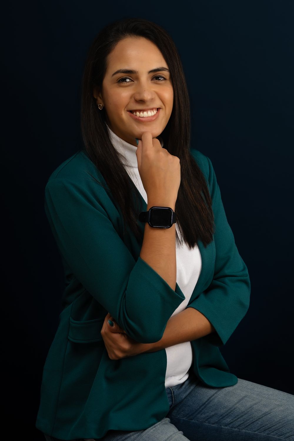 Professional portraits in teal blazer and white shirt against dark backdrop.