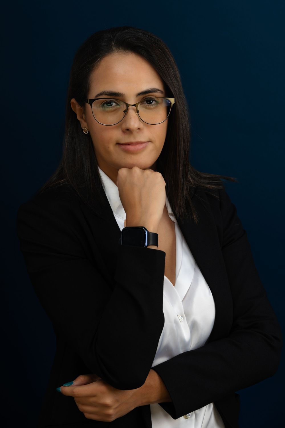 Business portrait series with black blazer and white shirt against navy backdrop.
