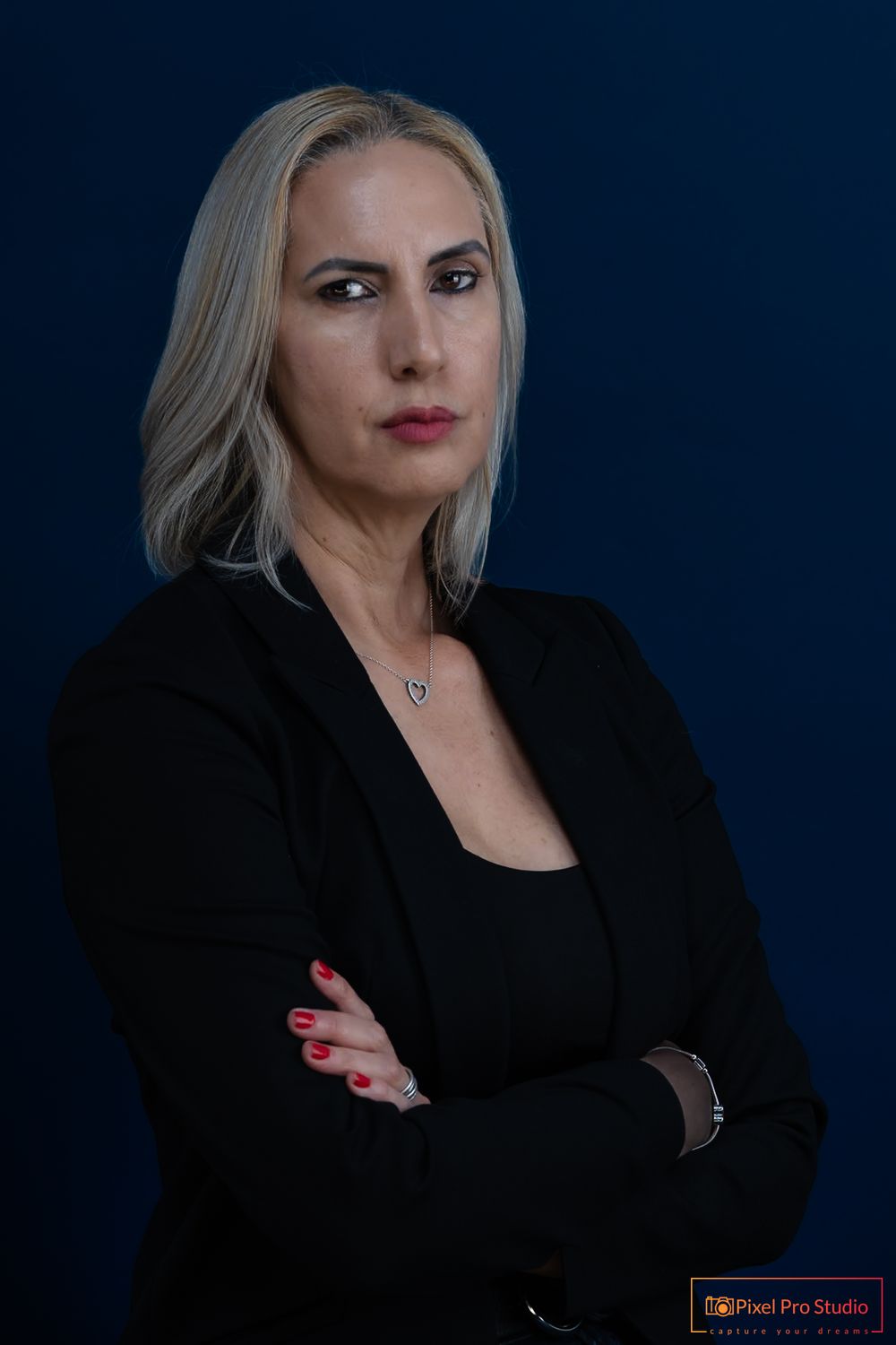 Corporate headshots with black blazer against navy backdrop showing confident poses.