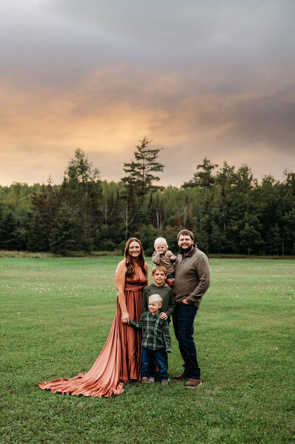 Family of five posing in field in Orr, MN.