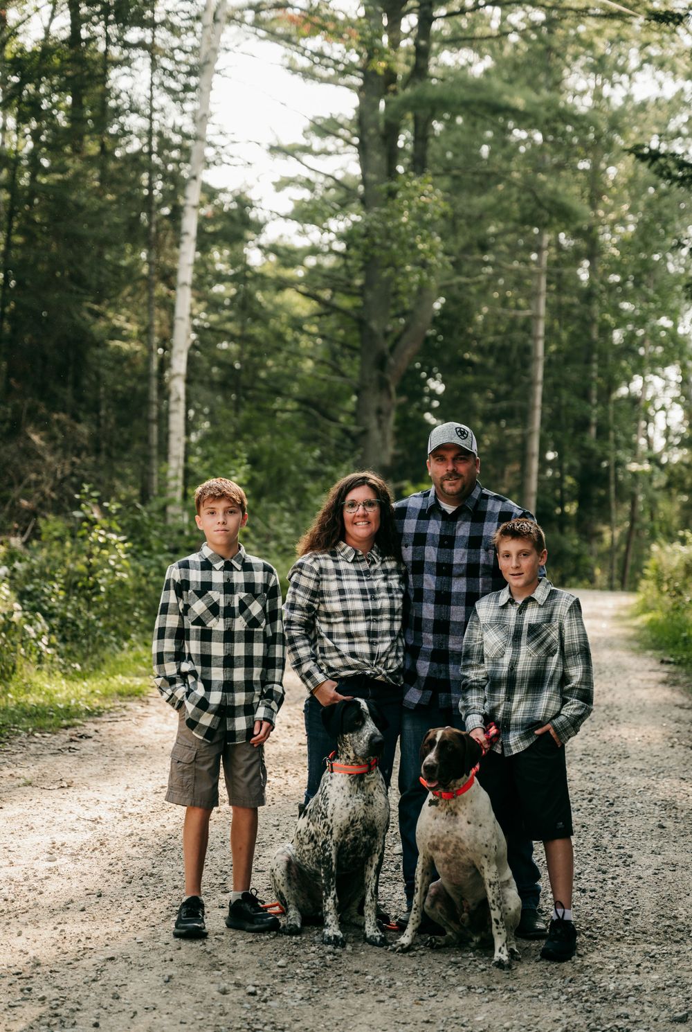 Family of four with two dogs posing for family photoshoot in Orr, Minnesota.