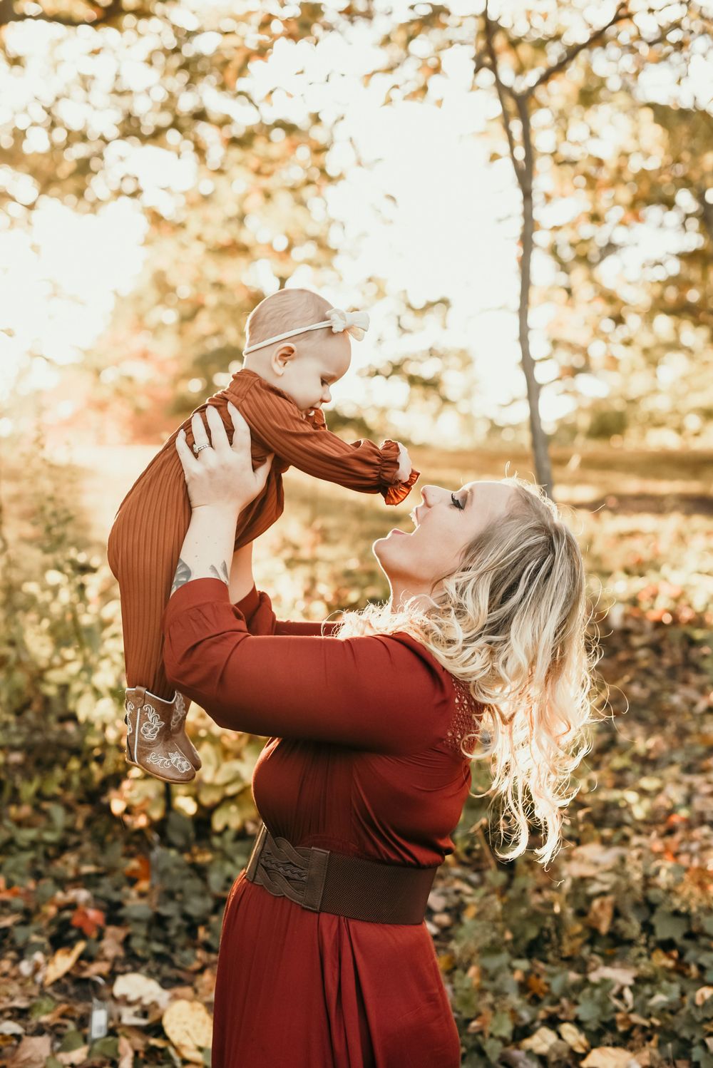A tender moment between parent and baby captured in warm autumn lighting.
