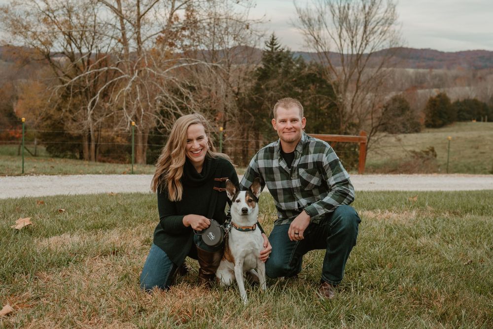 Family and dog portrait session in a scenic outdoor setting with mountains in the background.