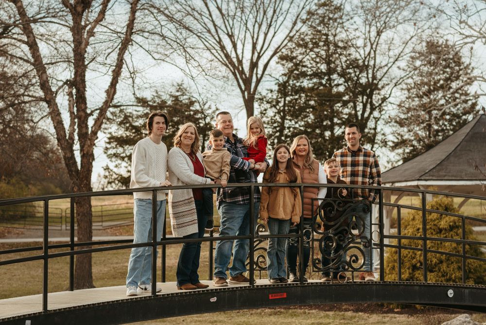 People gathered on a wooden deck or observation platform in late afternoon autumn light.