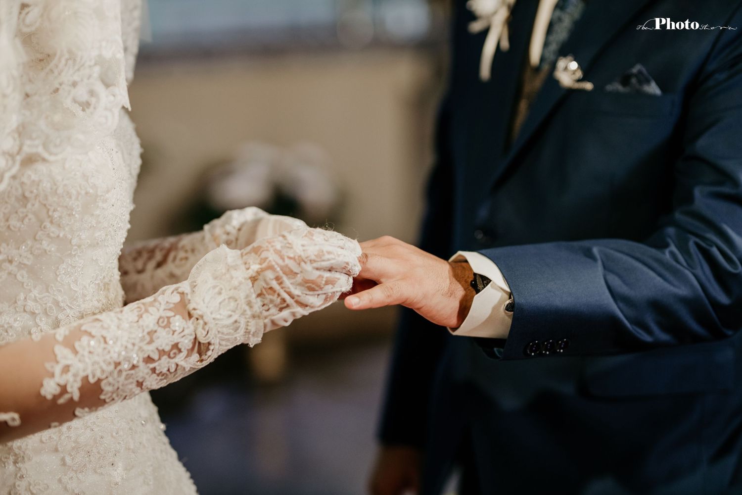 Intimate moment during a wedding ceremony with delicate lace details and formal attire.