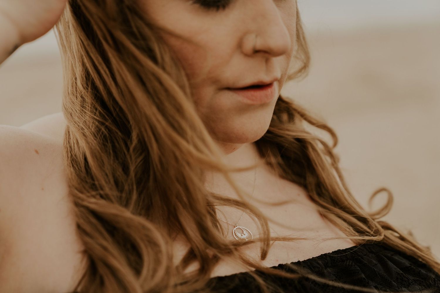 Close-up portrait of woman with flowing hair in natural golden light.