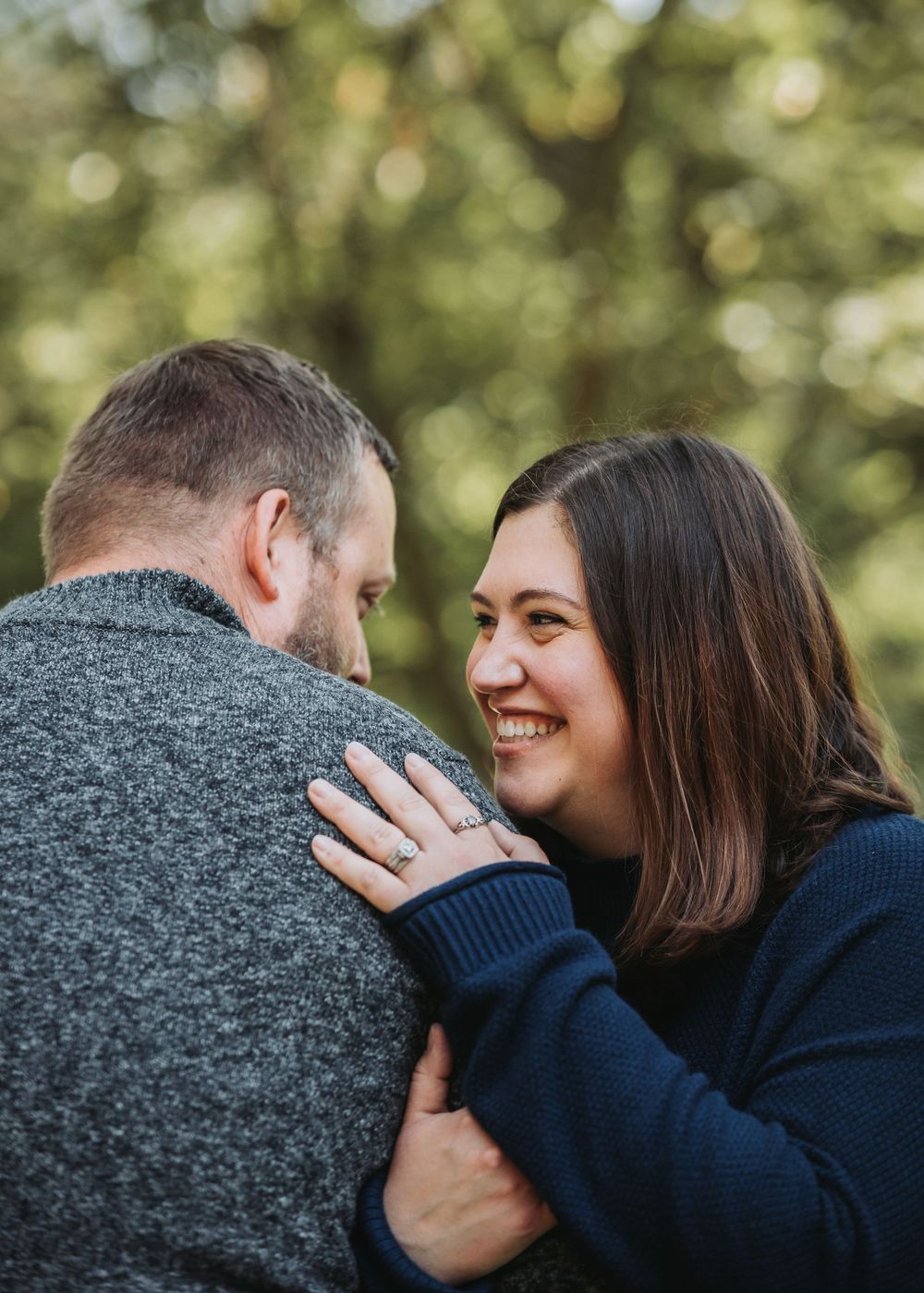 A couple embraces in a romantic pose during their engagement session at Liberty Lake Regional Park's botanical gardens in Seattle.