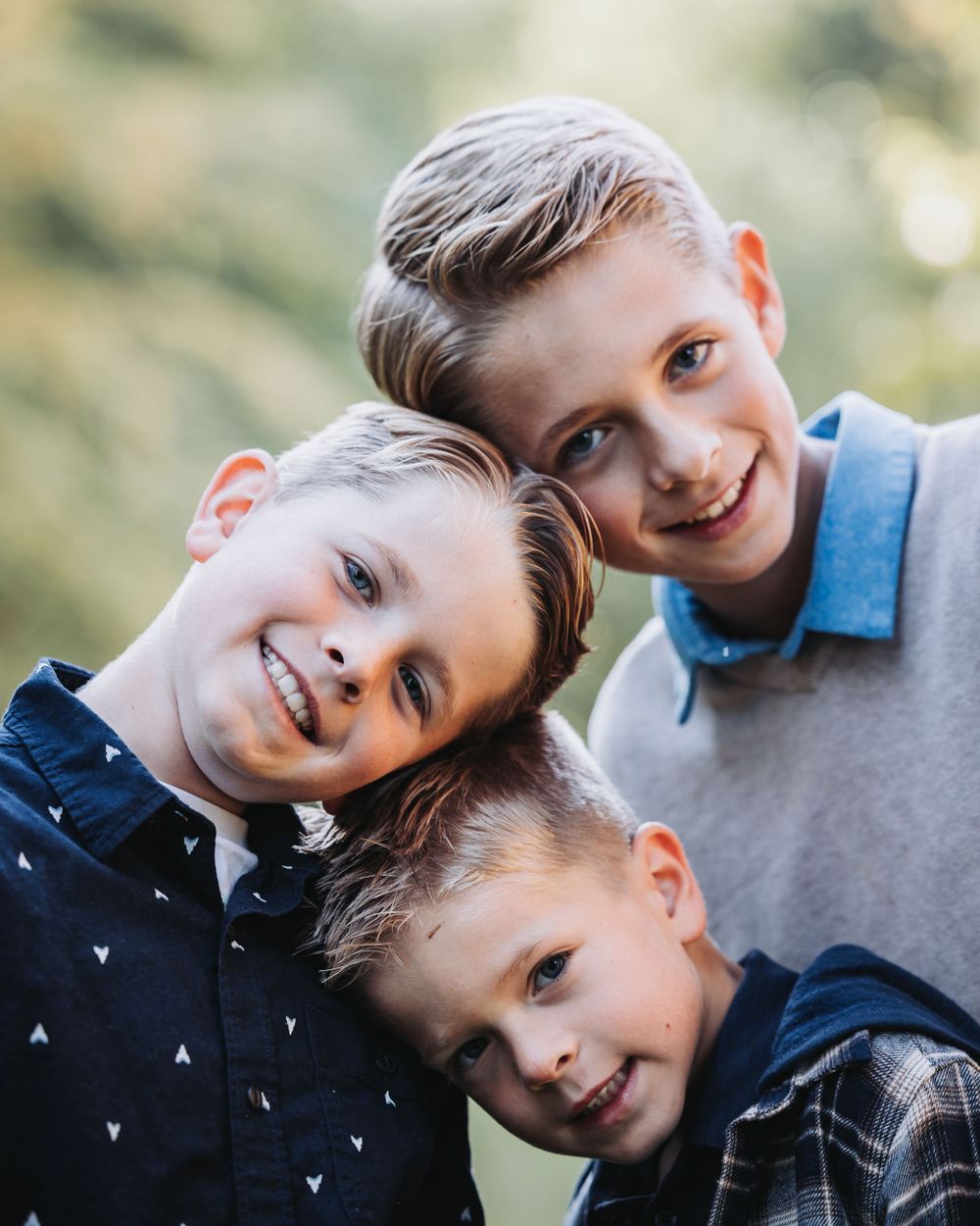 three brothers stand together in a picturesque fall scene at Finch Arboretum, framed by stunning autumn colors.