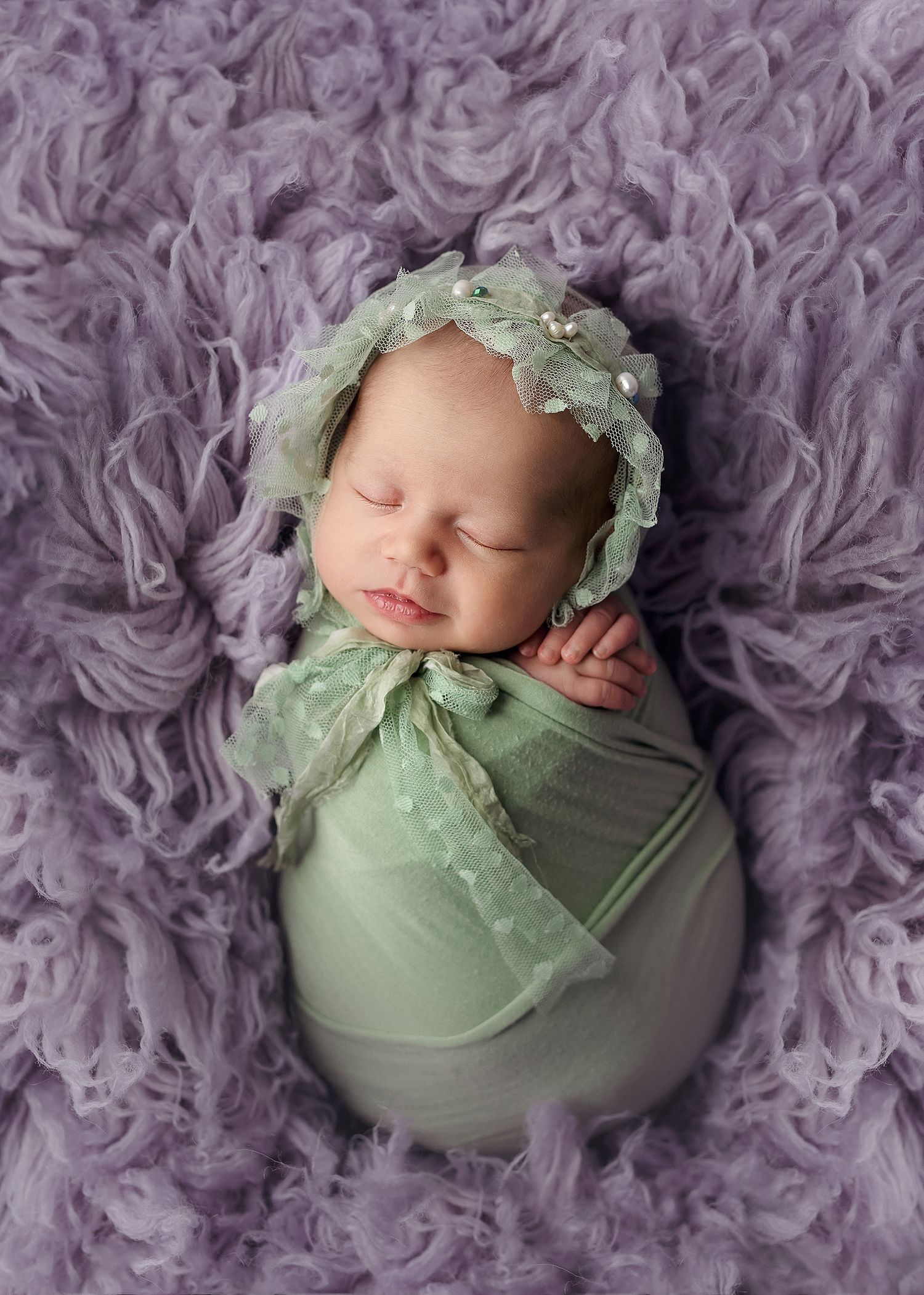 austin baby photography newborn in green swaddle on luneberry purple flokati rug
