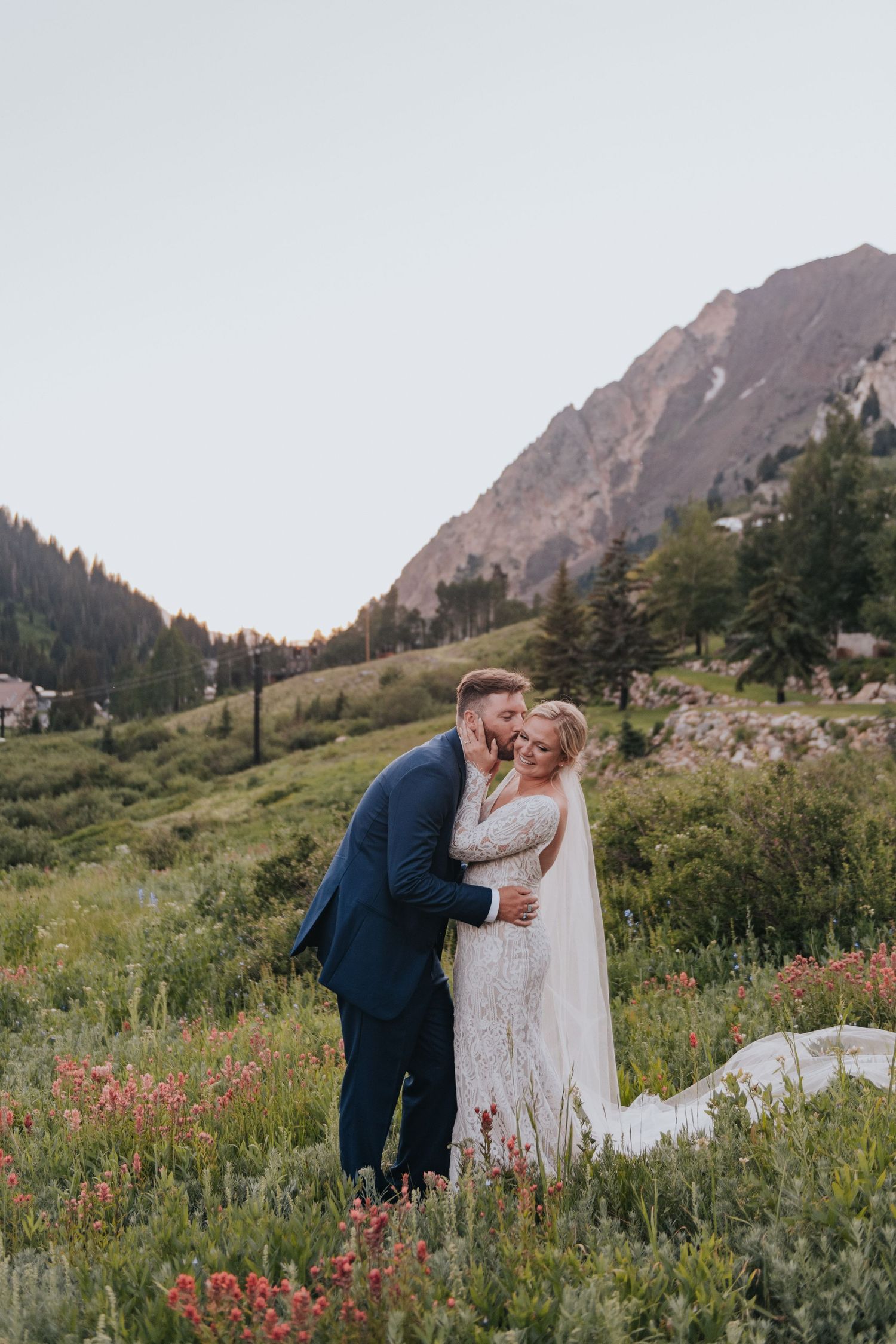 A couple poses for their photographer with a mountain backdrop at Snowpine Lodge near SLC Utah
