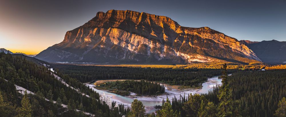 Majestic mountain reflecting in Bow River during sunset at Banff National Park.