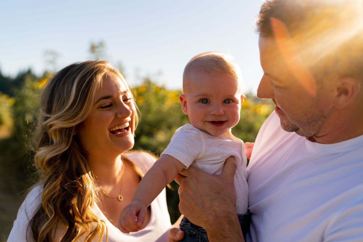 Family sharing tender moments during sunset in a golden-lit outdoor setting.