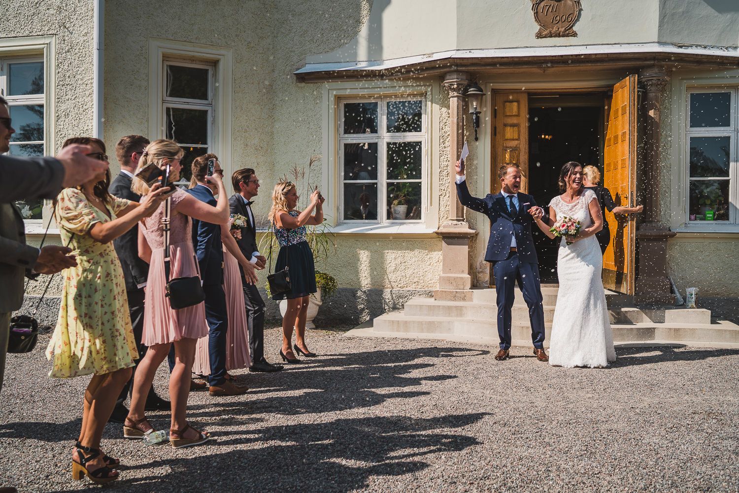 Brudpar blir firade av släkt och vänner efter ceremonin alla är glada och skrattar