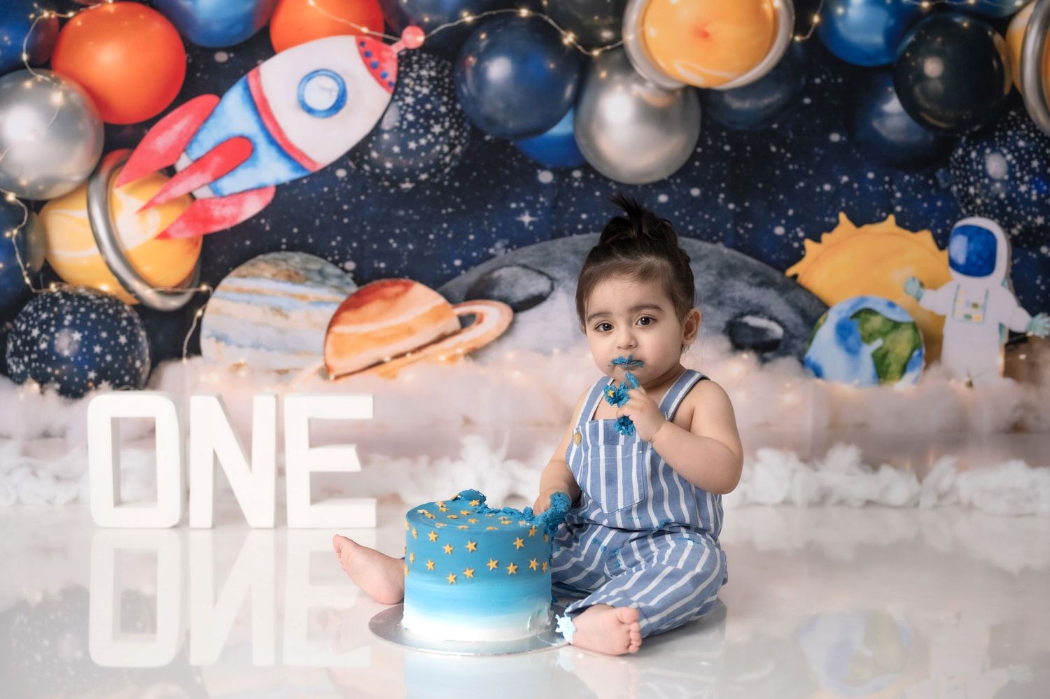 Space themed birthday setup with navy blue balloons and silver accents.