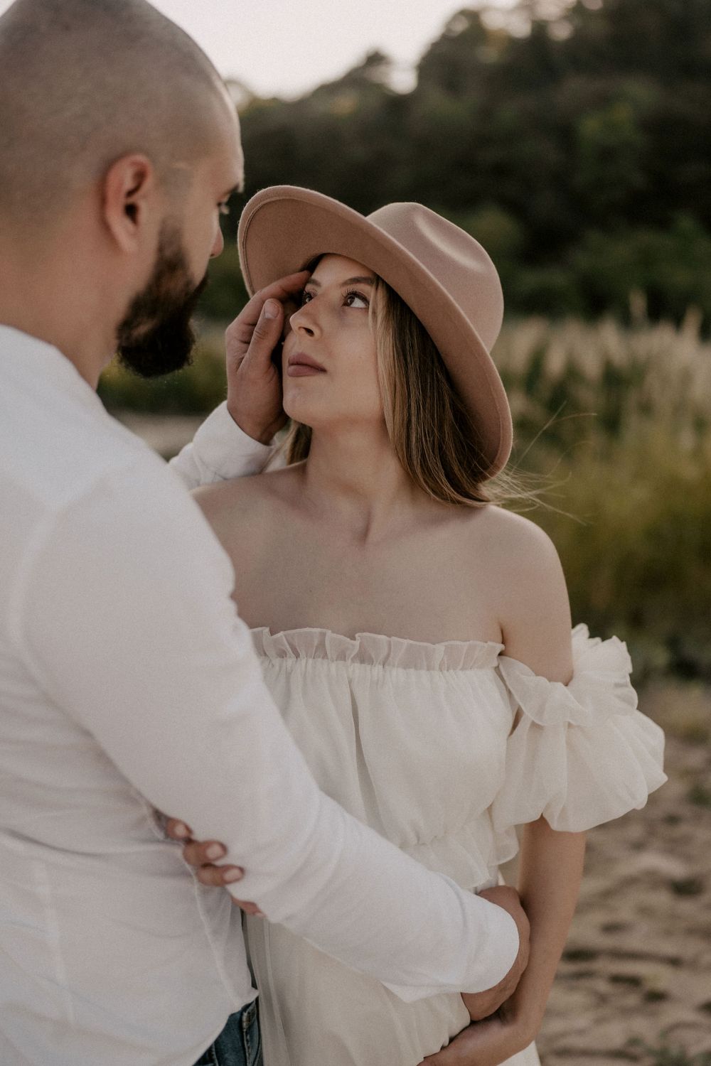 An intimate portrait of a couple embracing on a beach with golden light.