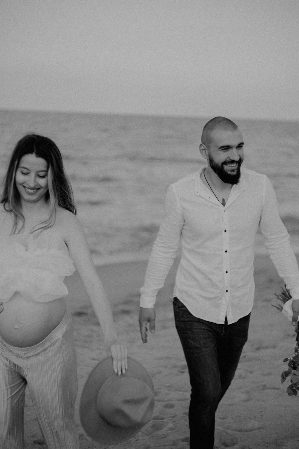 Black and white beach photoshoot featuring a couple in casual attire.