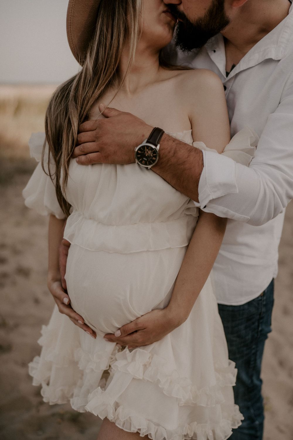 Detailed shots of white ruffled maternity dress during outdoor photo session.