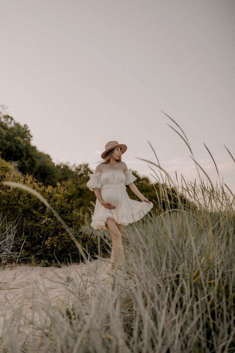 A graceful pose captured among windswept beach grass at golden hour.