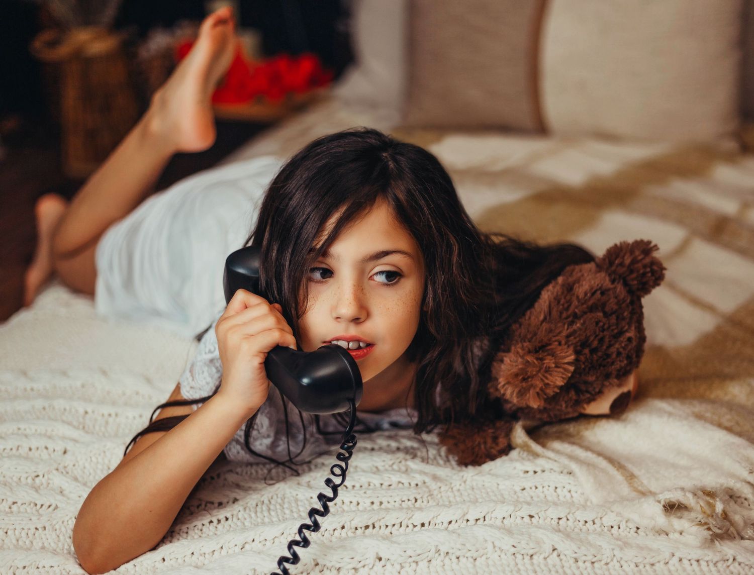 Young girl holding her teddy bear on the phone in Houston, TX