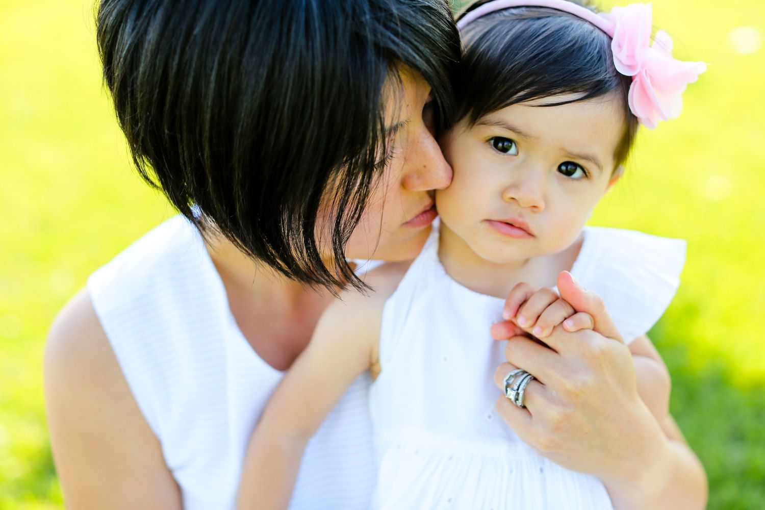 Tender family moment captured against bright yellow background in studio setting.