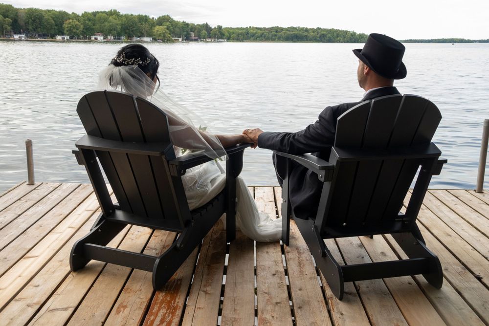 Bride and groom sitting looking out at the lake