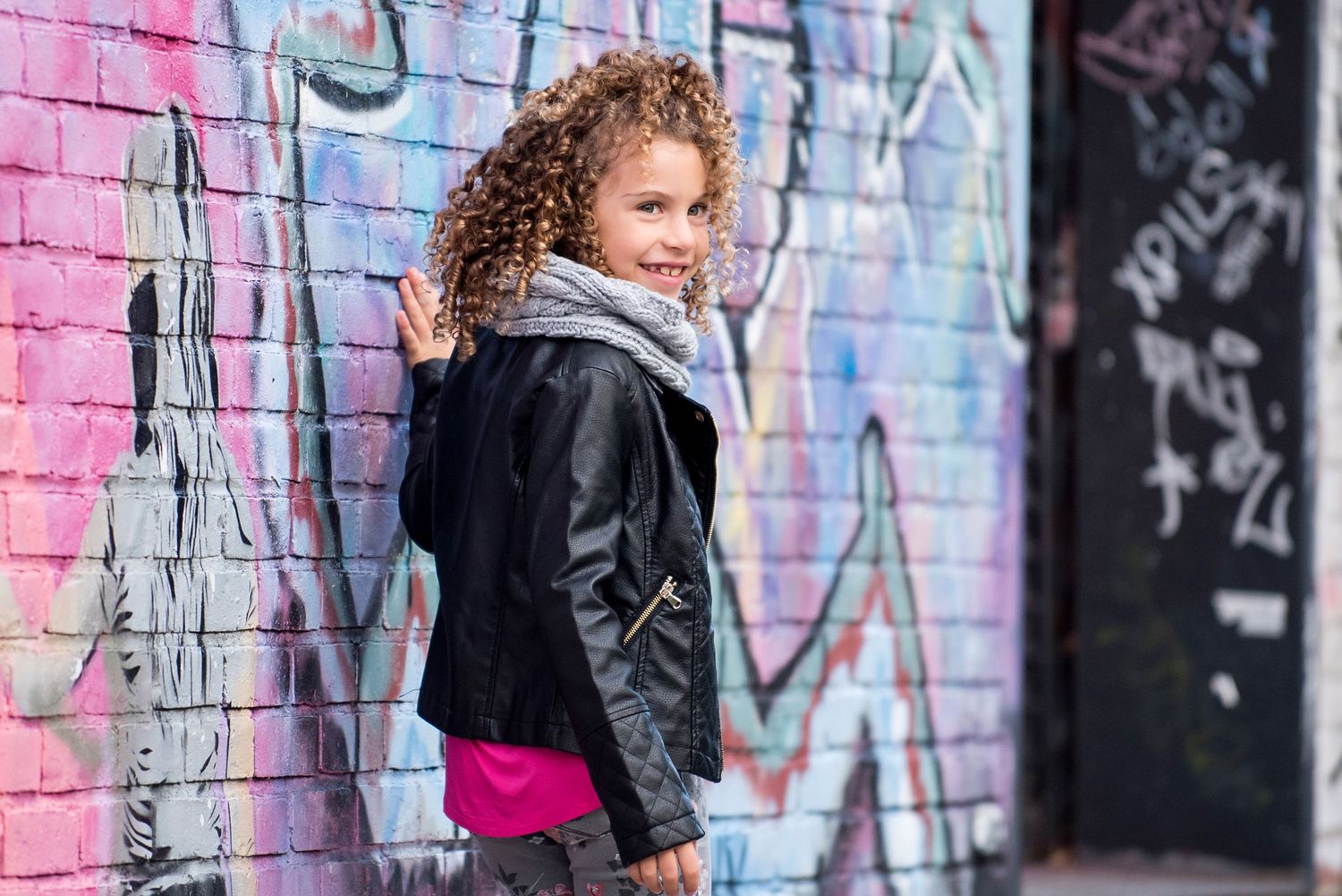 female child model wearing stylish clothes with graffiti background