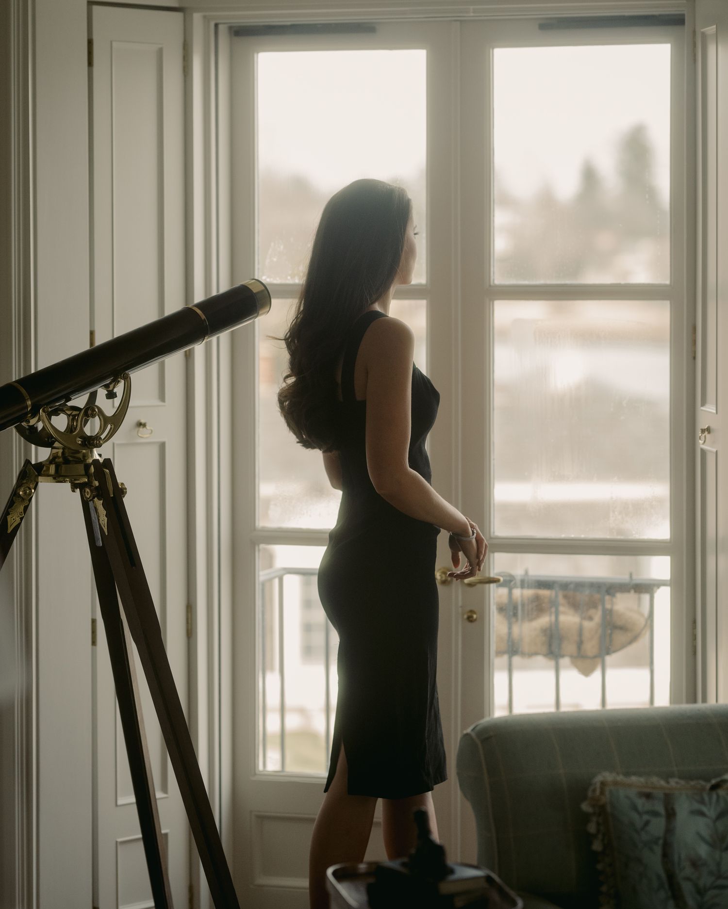 Sunlit room with telescope and romantic couple in silhouette.