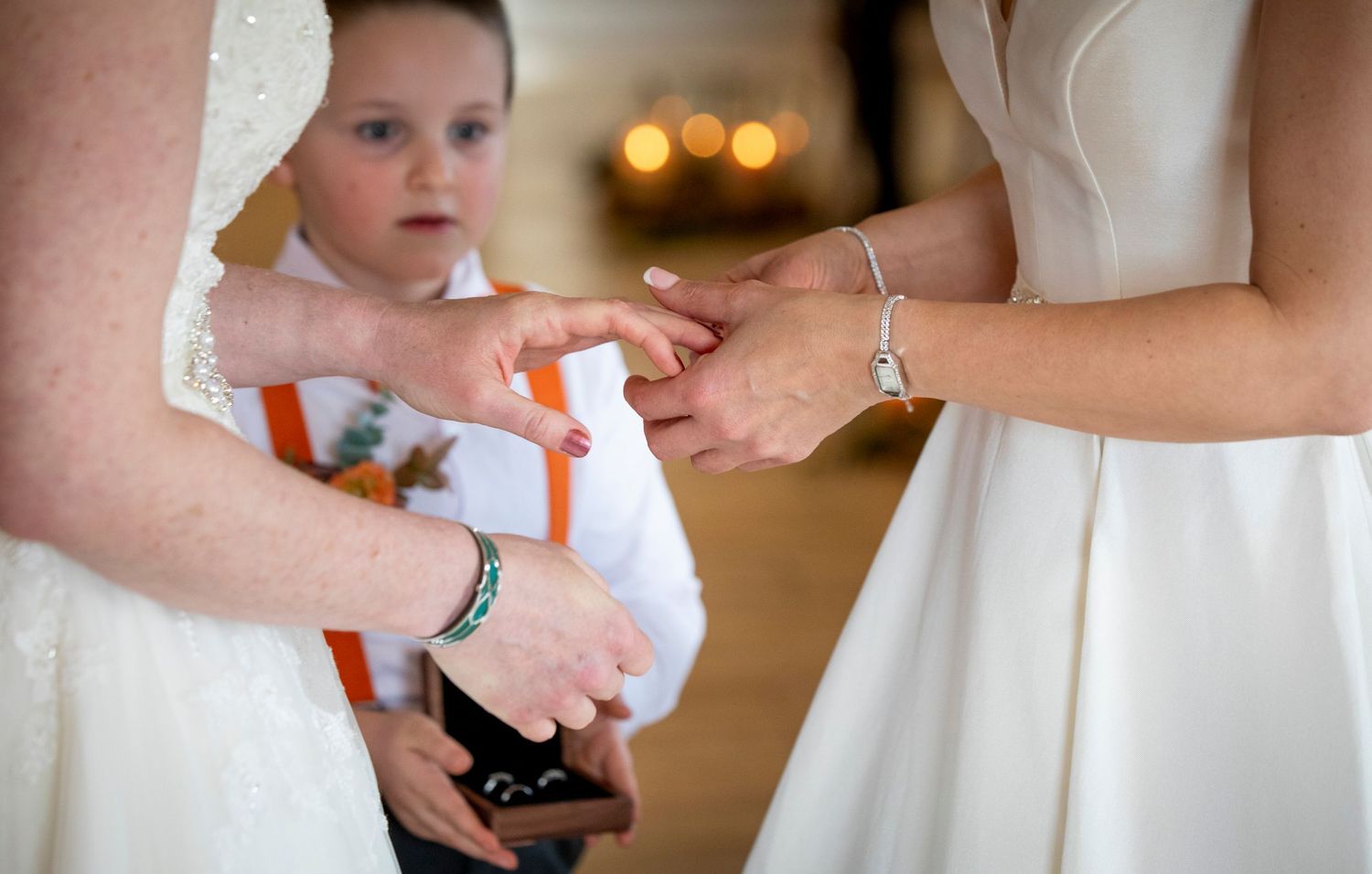 Close-up shot of hands exchanging rings during an intimate wedding ceremony.