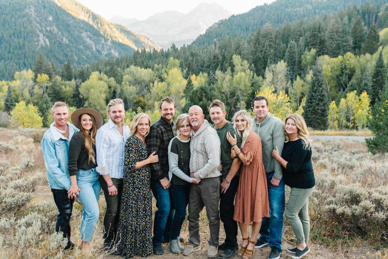 Extended family portrait in front of mountain vista with autumn colors.