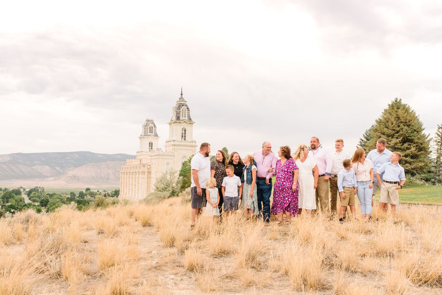 Extended group photo taken on a hillside with a historic building visible in the background.