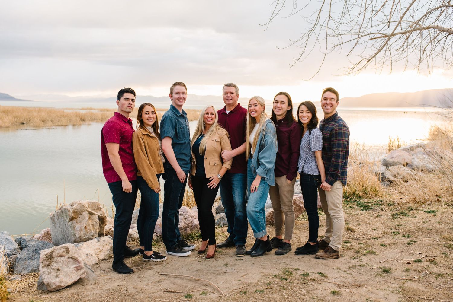 Group portrait by lakeside with mountains and sunset in background.
