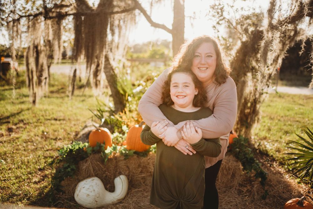 Tender moment captured between two people with autumn decorations and vintage truck in background.