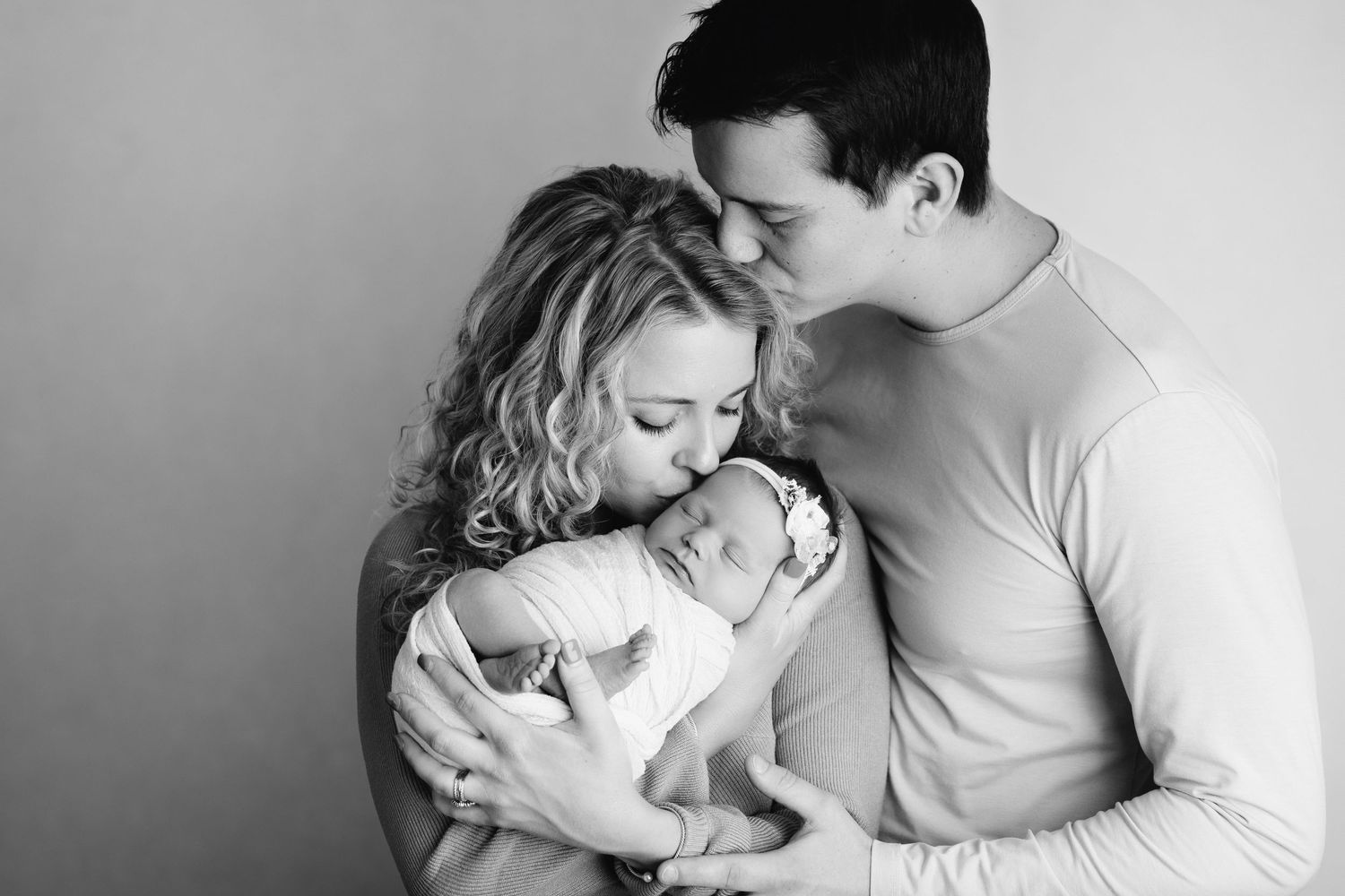 new mom and dad pose with their baby girl for studio photo session