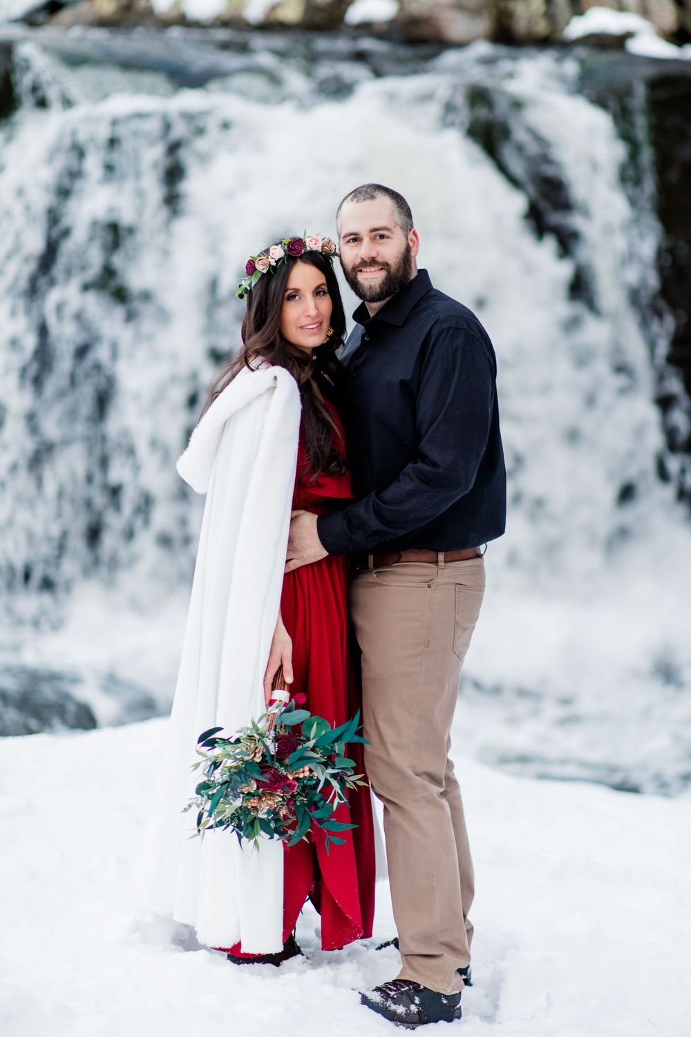Winter engagement photos by cascading waterfall with snow and ice.
