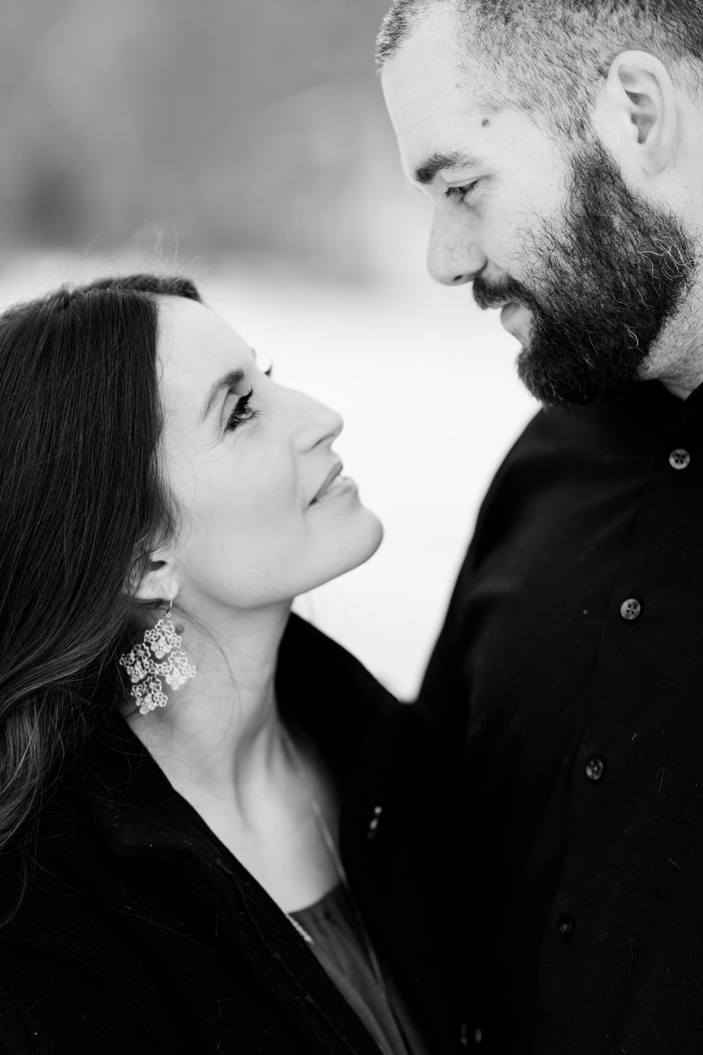An intimate black and white portrait of a couple gazing at each other.