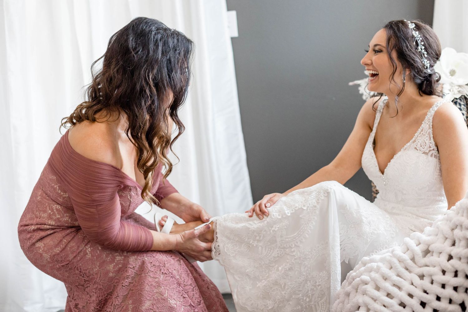 mom helping bride put on shoes