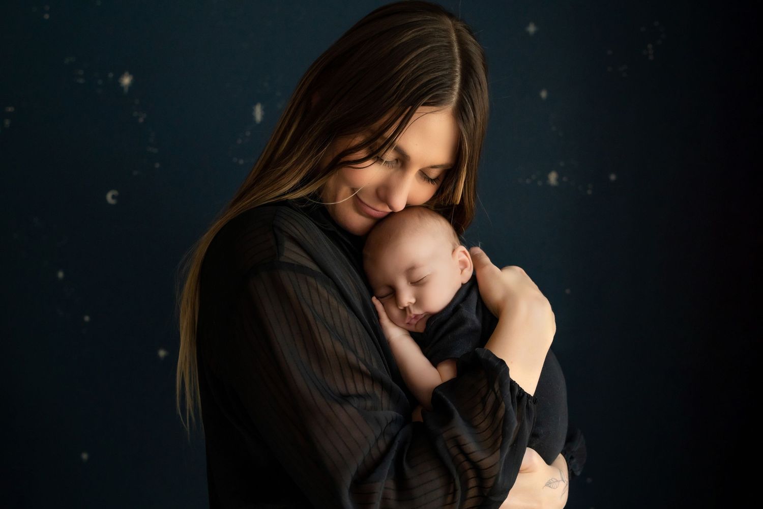 Intimate portrait against starry dark background showing tender family moment.