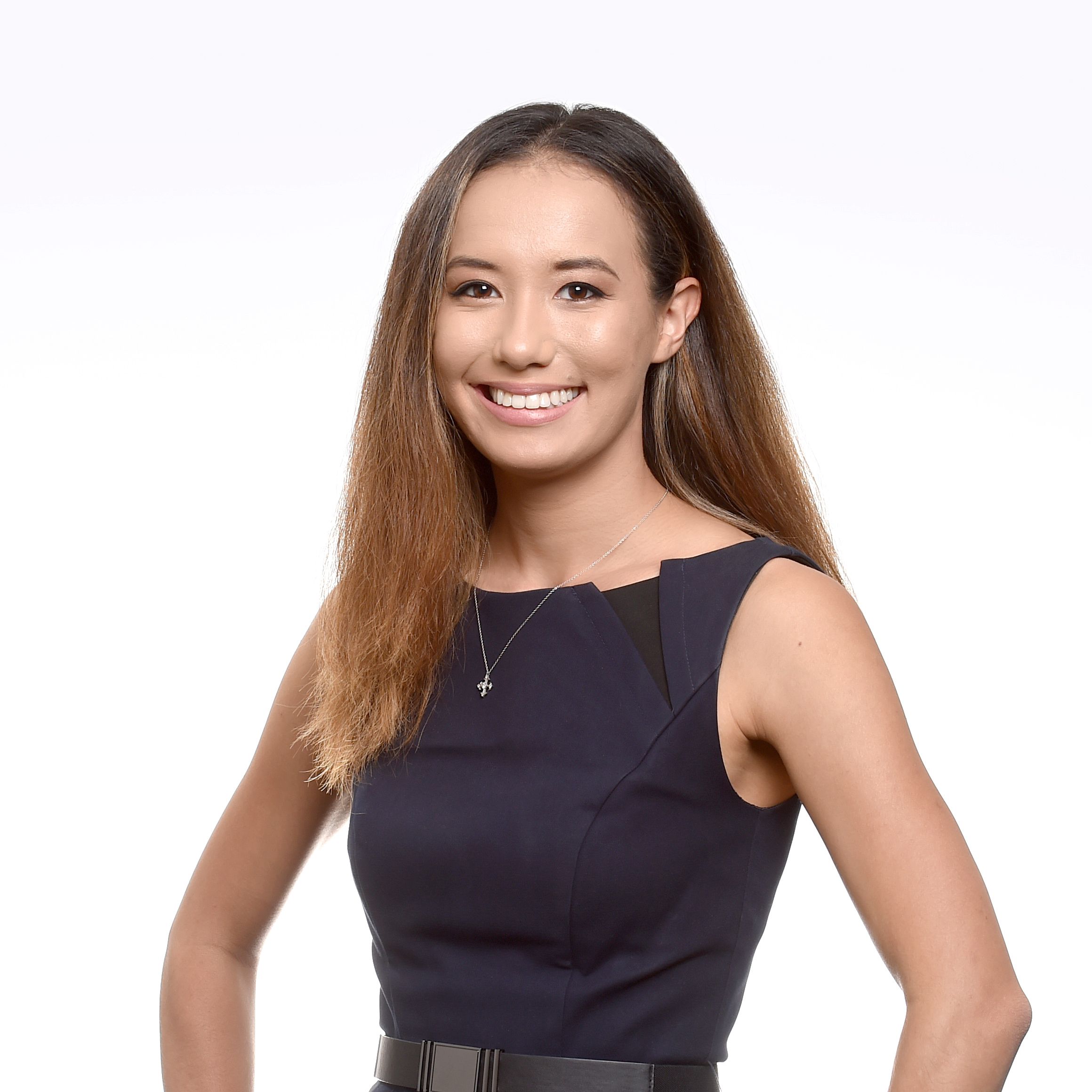 Headshot on white background with hands on hips