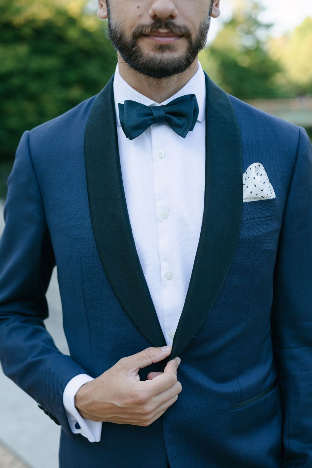 Classic navy tuxedo with bow tie and patterned pocket square closeup.