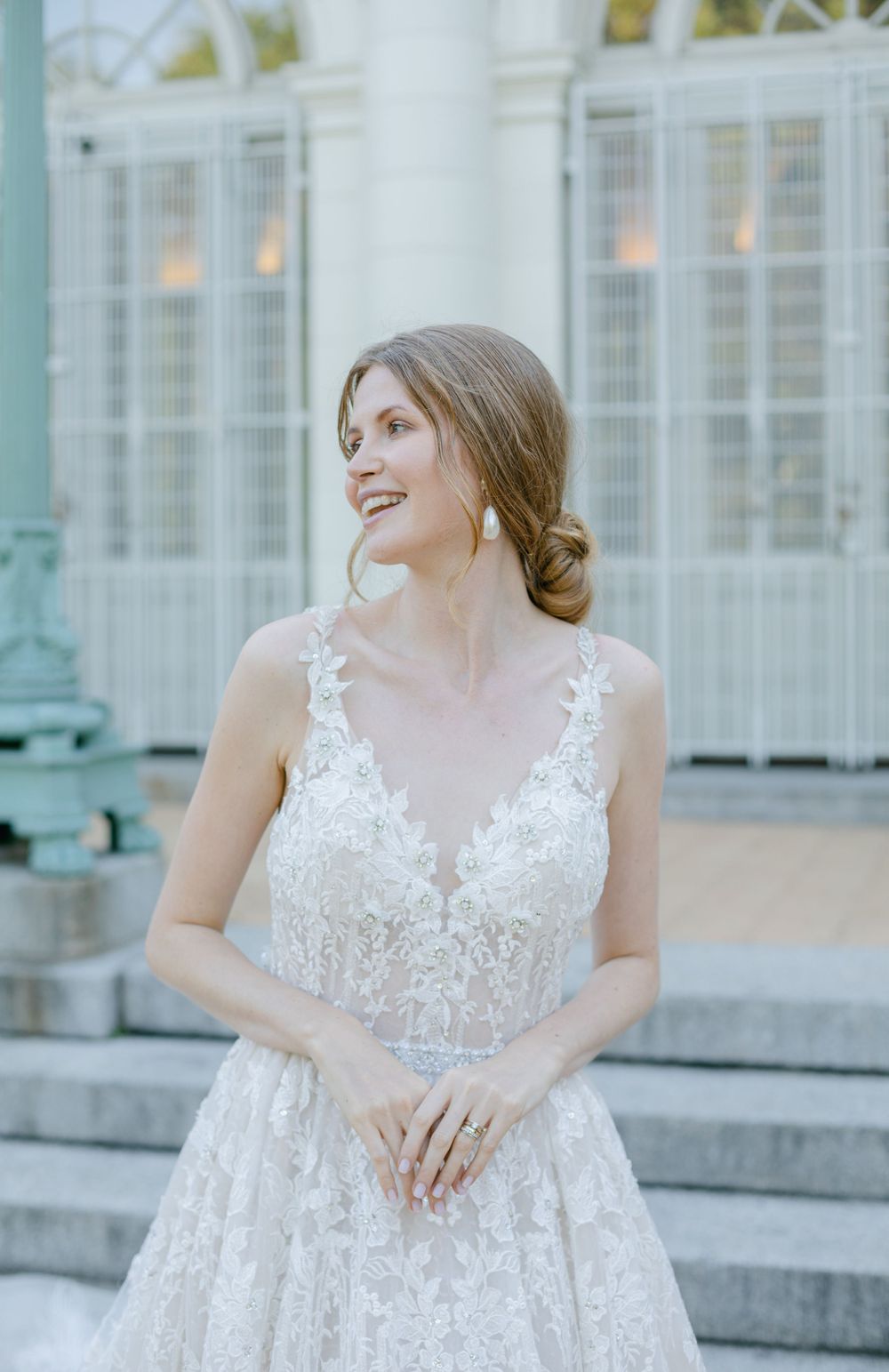 Elegant wedding dress with lace details photographed on stone steps.