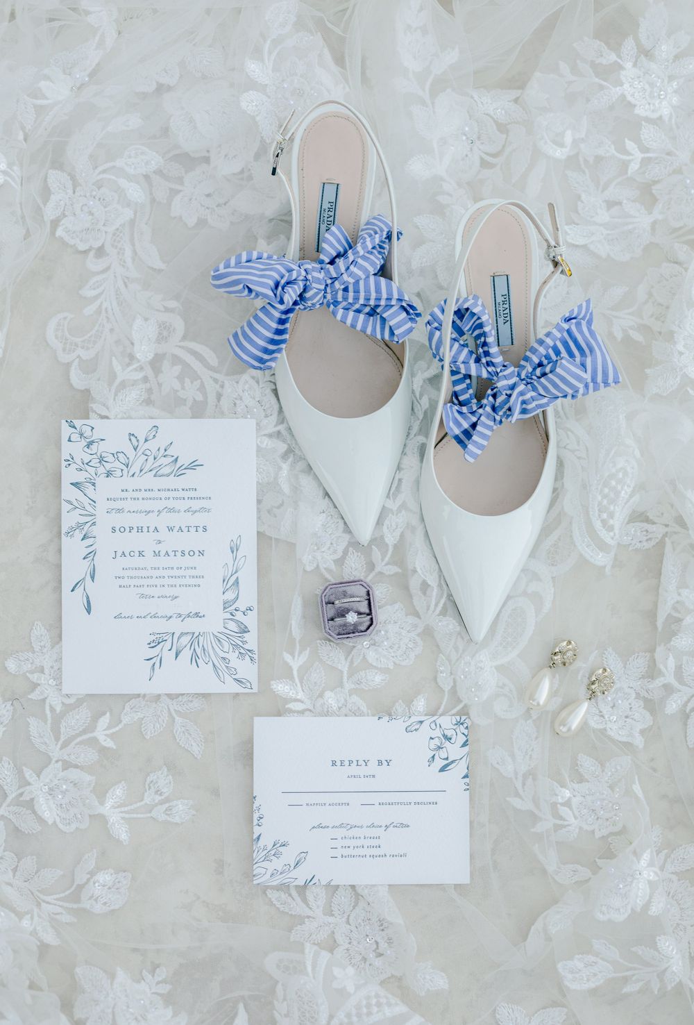 Wedding invitation suite with white pointed-toe shoes adorned with blue striped bows.