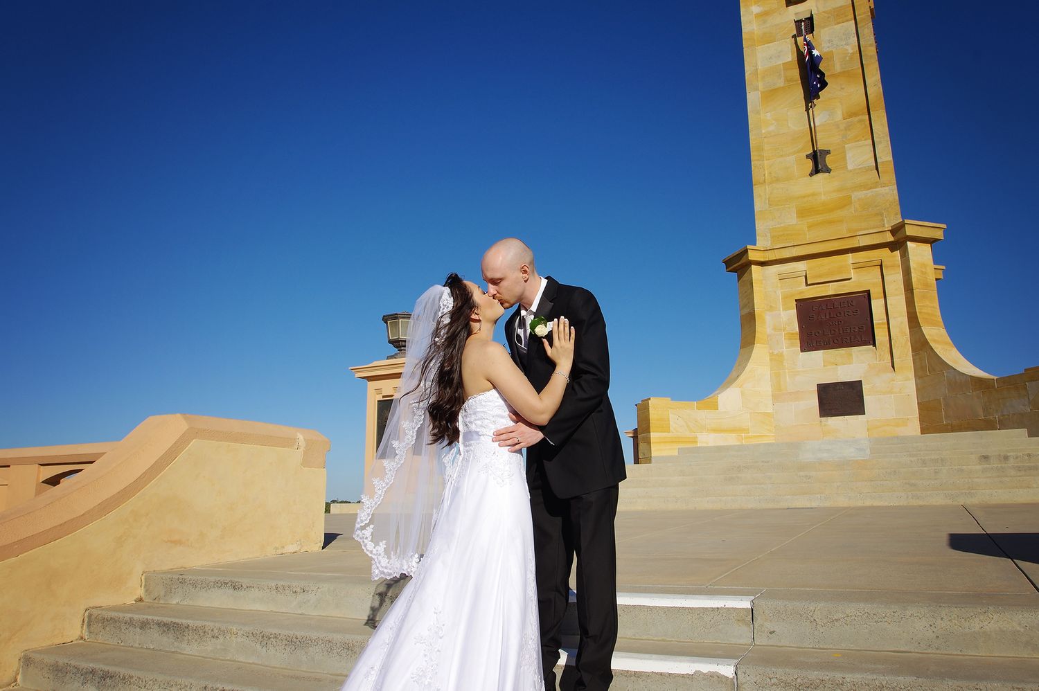 bride and groom kissing on steps