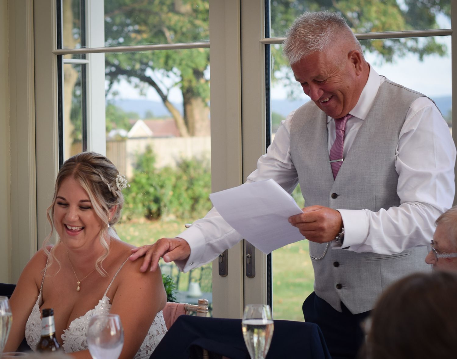 Reception speech moment with guests enjoying champagne at elegant wedding venue.