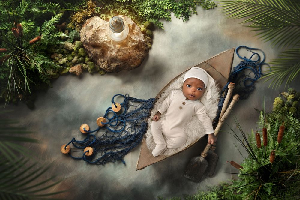 Creative holiday themed newborn photoshoot with evergreen branches and festive props.