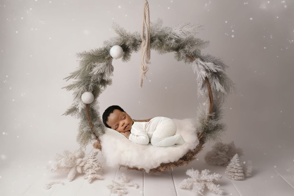 Winter wonderland themed newborn portrait with silver decorations and snowy effects.