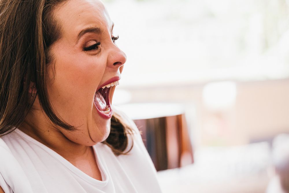 Side profile of someone expressing extreme excitement with mouth wide open.