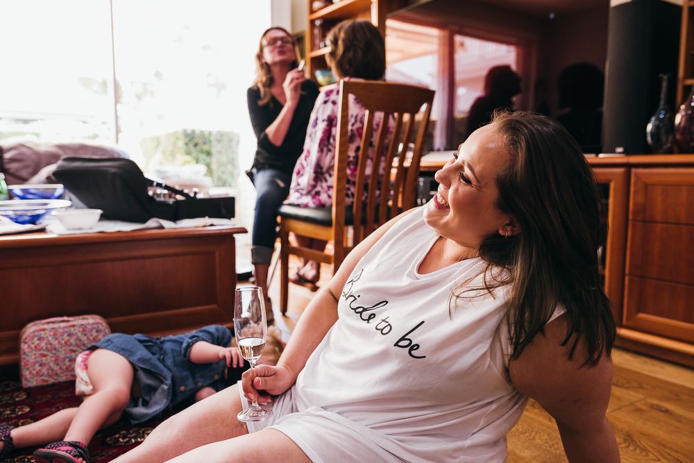 Casual indoor scene showing people relaxing and laughing in a home setting.