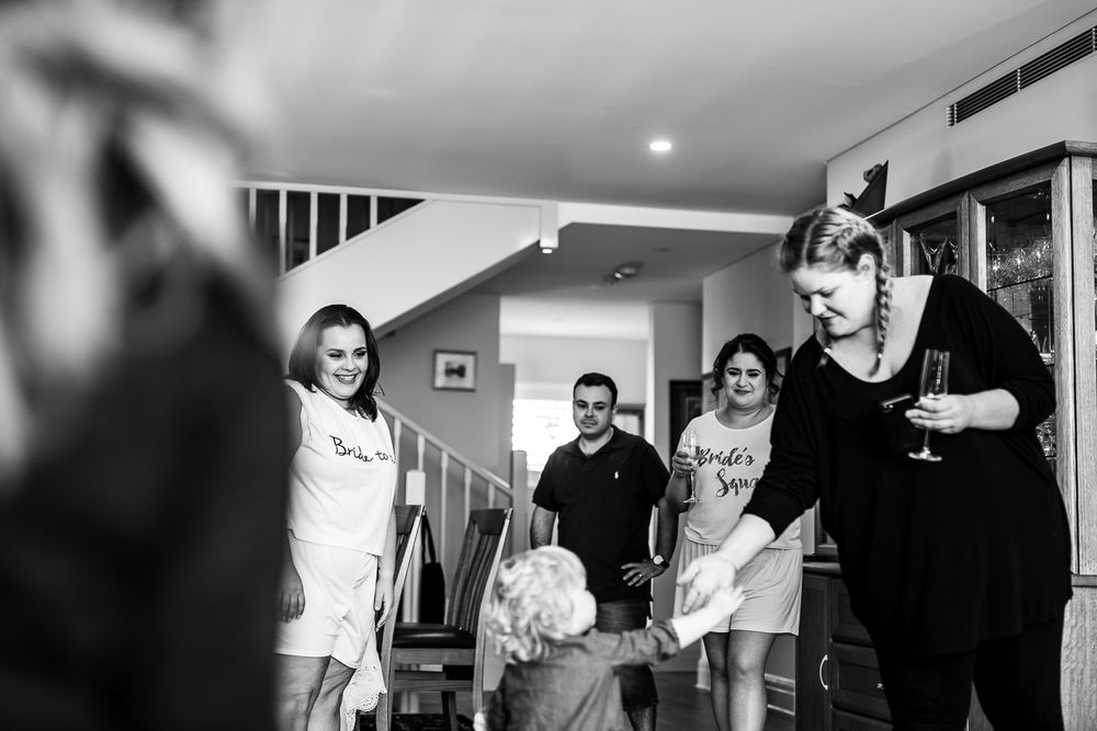 People gathered in a home interior with white walls and modern decor.