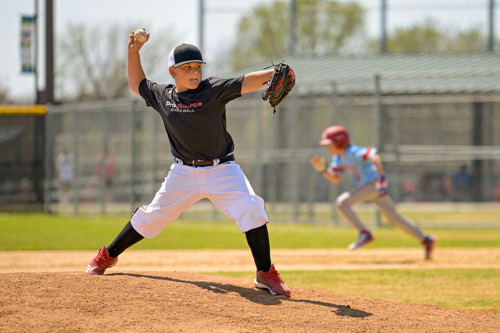 youth boys baseball player game action photo pitcher throwing to batter frisco texas